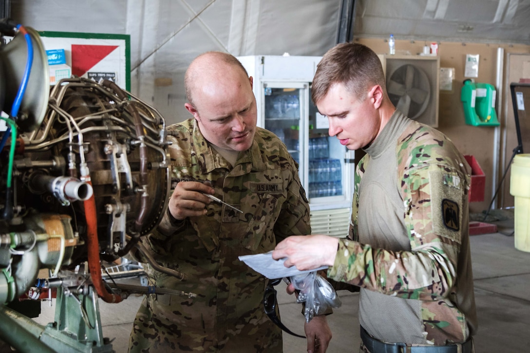 Soldiers discuss maintenance steps for an HH-60 Black Hawk helicopter engine at Bagram Airfield, Afghanistan, May 25, 2017. Army photo by Capt. Brian Harris
