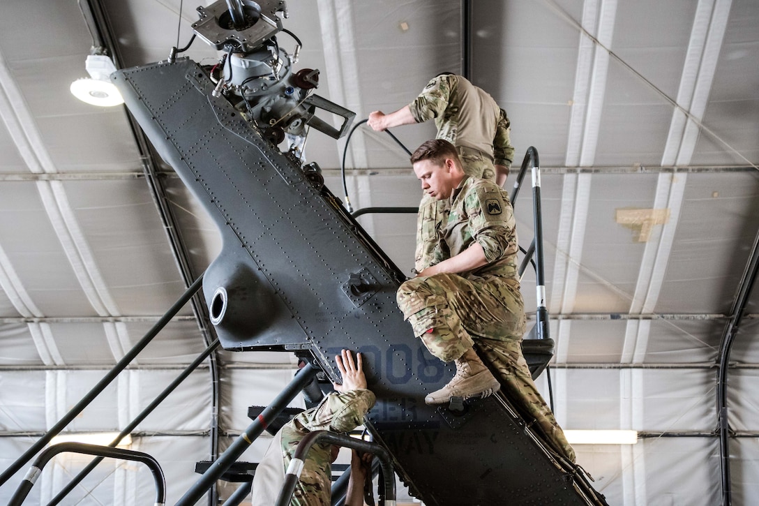 Soldiers work to disassemble the tail rotor housing during maintenance on an HH-60 Black Hawk helicopter at Bagram Airfield, Afghanistan, May 25, 2017. Army photo by Capt. Brian Harris