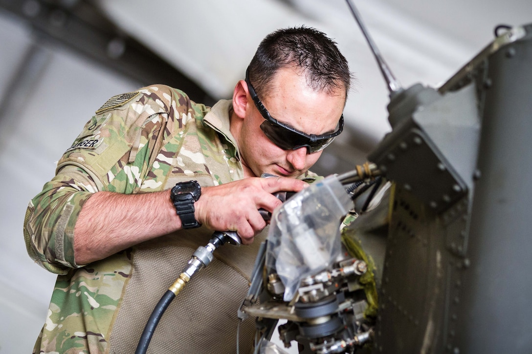 A soldier disassembles part of the tail rotor housing during maintenance on an HH-60 Black Hawk helicopter at Bagram Airfield, Afghanistan, May 25, 2017. Army photo by Capt. Brian Harris
