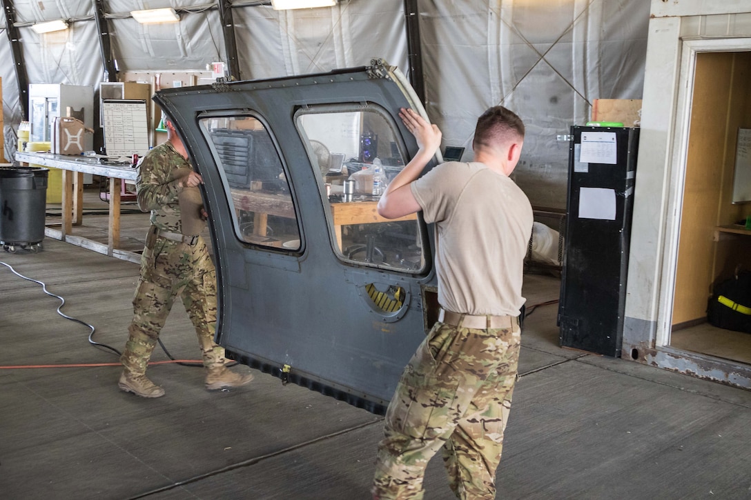 Soldiers remove a door from an HH-60 Black Hawk helicopter during aircraft maintenance at Bagram Airfield, Afghanistan, May 25, 2017. Army photo by Capt. Brian Harris  