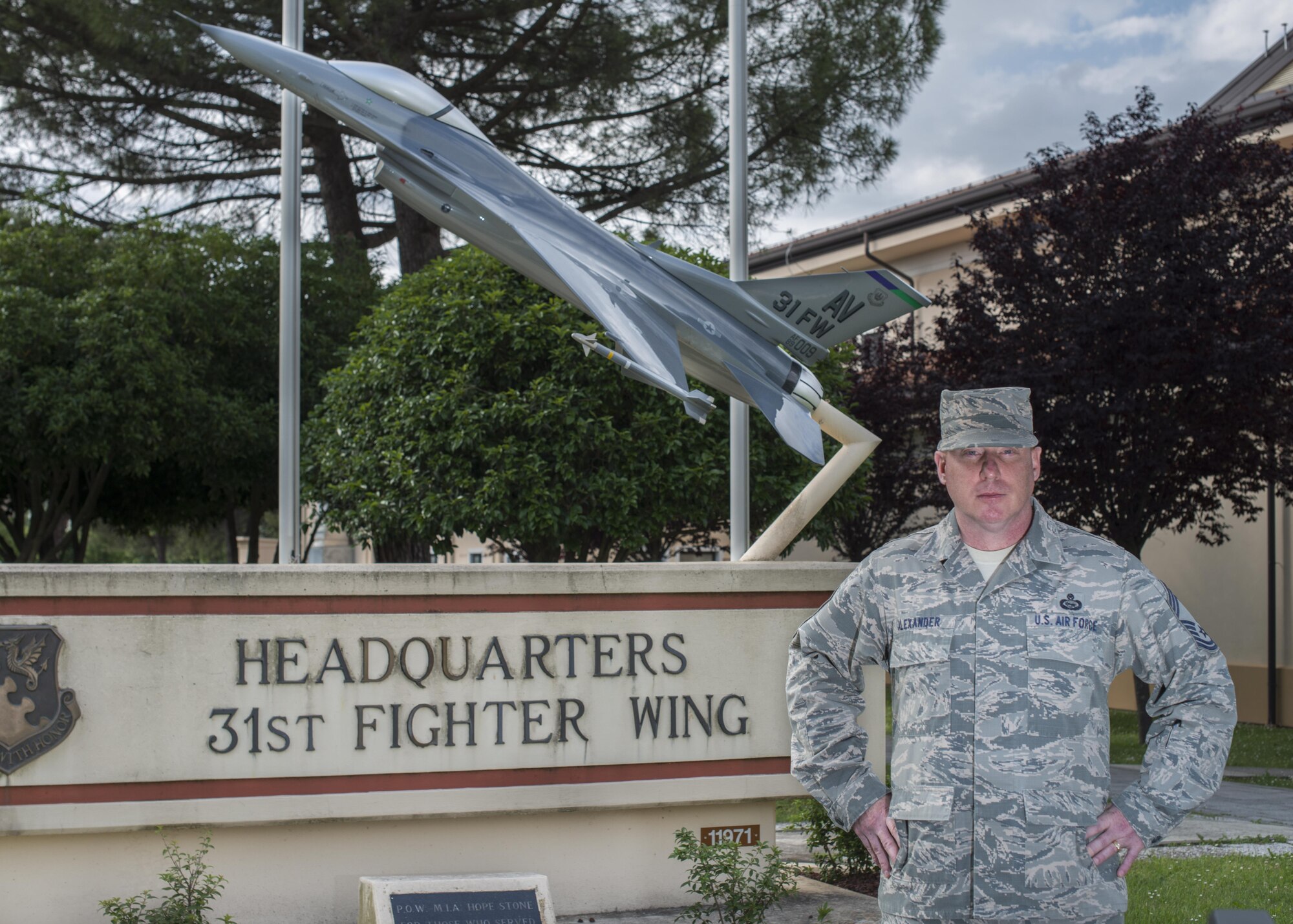 Chief Master Sgt. Michael Alexander stands in front of the 31st Fighter Wing static display on May 26, 2017 at Aviano Air Base, Italy. His portrait is for his commentary on the history of fighter pilots. (U.S. Air Force photo by Senior Airman Cory Bush)