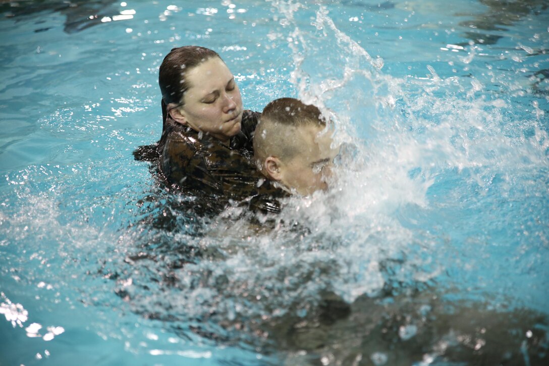 Seaman Rebecca Ward, a corpsman with The Basic School, simulates a panicking victim and submerges Staff Sgt. Adam Brooks, a precision weapons repairer and technician with Weapons Training Battalion, at Ramer Hall on Feb. 4, 2014. Brooks had to break away from the panicking victim and rescue her, as a part of Water Survival Advance qualification course.