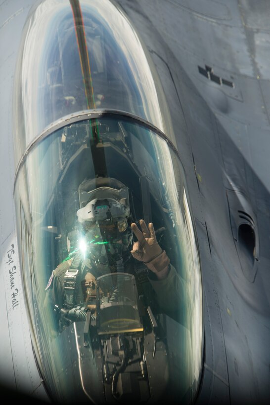 A U.S. Air Force F-16 Fighting Falcon pilot waves to the boom operator of a KC-135 Stratotanker during an air-to-air refueling mission over Spangdahlem Air Base, Germany, May 30, 2017. During the refueling training approximately 60,000 pounds of jet fuel were used to fuel 10 F-16 Fighting Falcons. (U.S. Air Force photo by Senior Airman Dawn M. Weber)