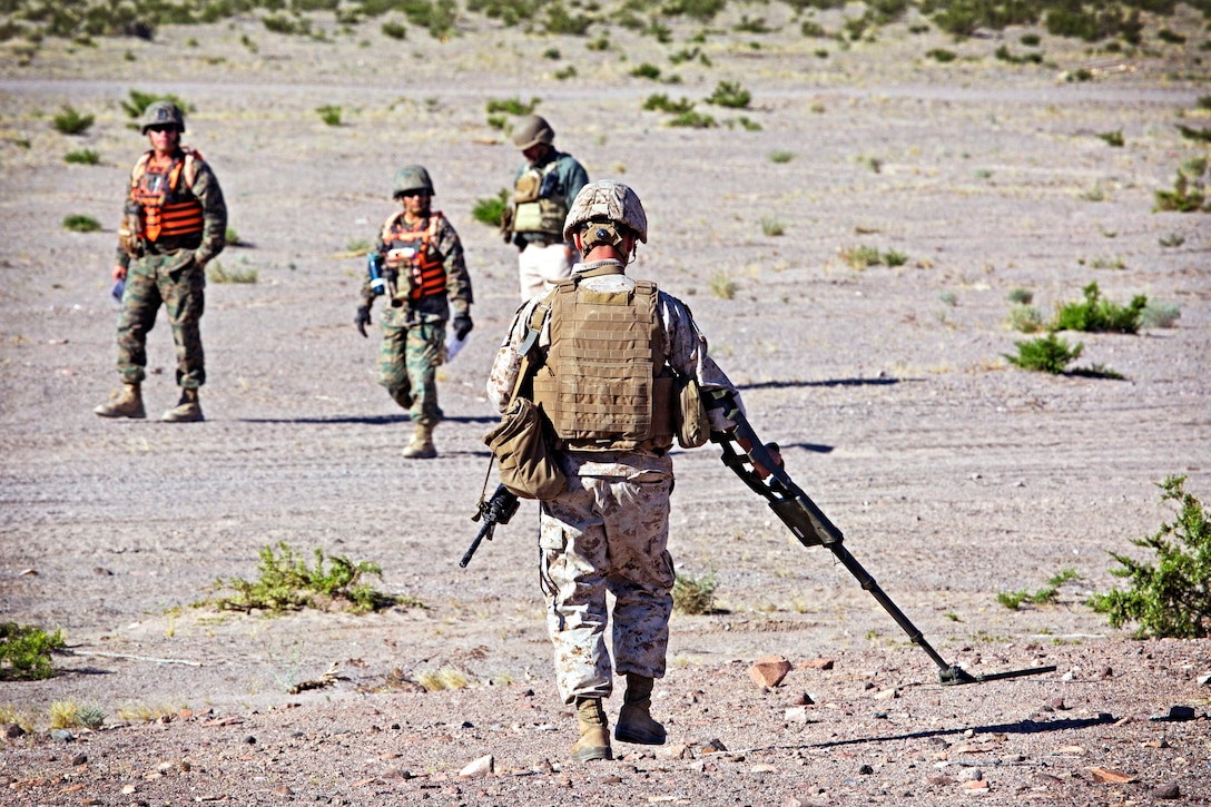 A Marine uses a metal detector seeking simulated improvised explosion devices while participating in a live-fire and aircraft recovery mission during a training exercise at Marine Corps Air Ground Combat Center Twentynine Palms, Calif., May 24, 2017. Marine Corps photo by Lance Cpl. Becky L. Calhoun