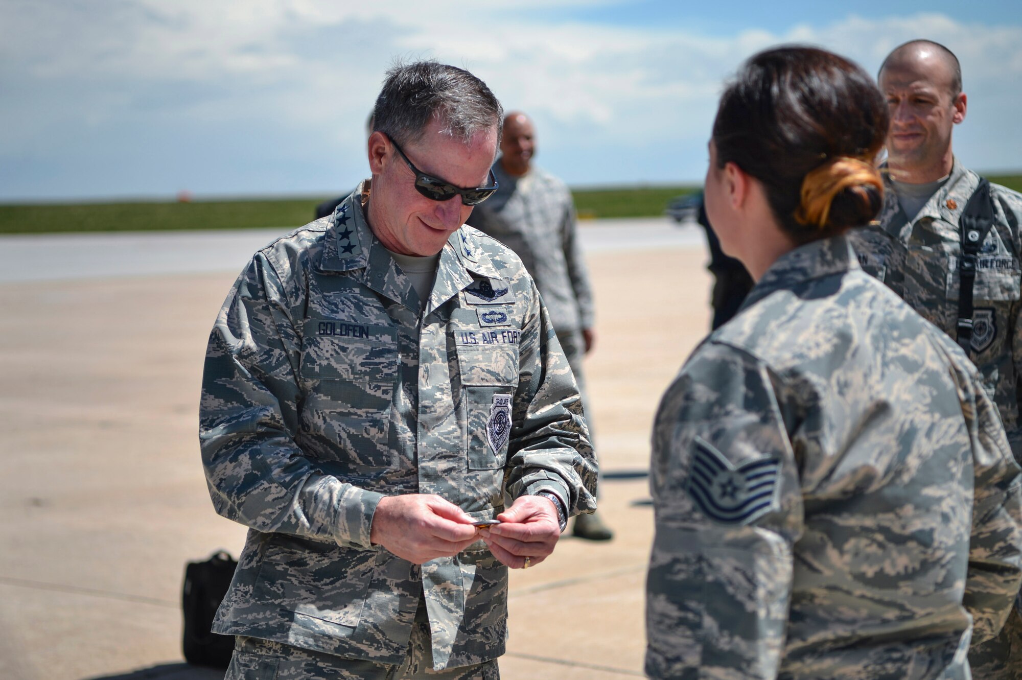Gen. David L. Goldfein, Chief of Staff of the U.S. Air Force, receives a 140th Medical Group coin from Tech Sgt. Adrianna Jakupi, 140th MDG 140th readiness and training NCO, May 25, 2017, on Buckley Air Force Base, Colo. Jakupi briefed Goldfein on the mission capabilities of the National Guard Chemical, Biological, Radiological, Nuclear and High Yield Explosive Enhanced Response Force Package. (U.S. Air Force photo by Airman 1st Class Holden S. Faul/ Released)