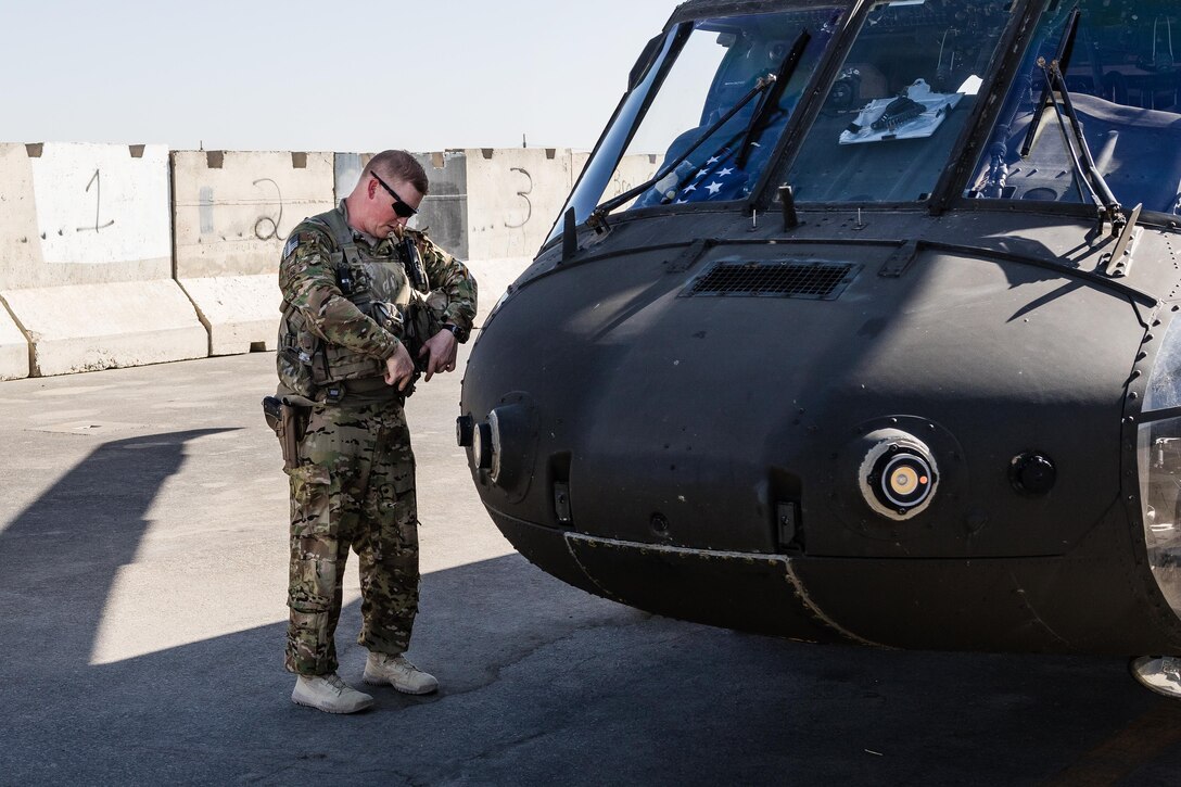 A soldier secures his gear outside a UH-60 Black Hawk helicopter before a flight at Kandahar Airfield, Afghanistan, May 27, 2017. The pilot is assigned to the 7th Infantry Division’s 16th Combat Aviation Brigade, Task Force Warhawk. Army photo by Capt. Brian Harris