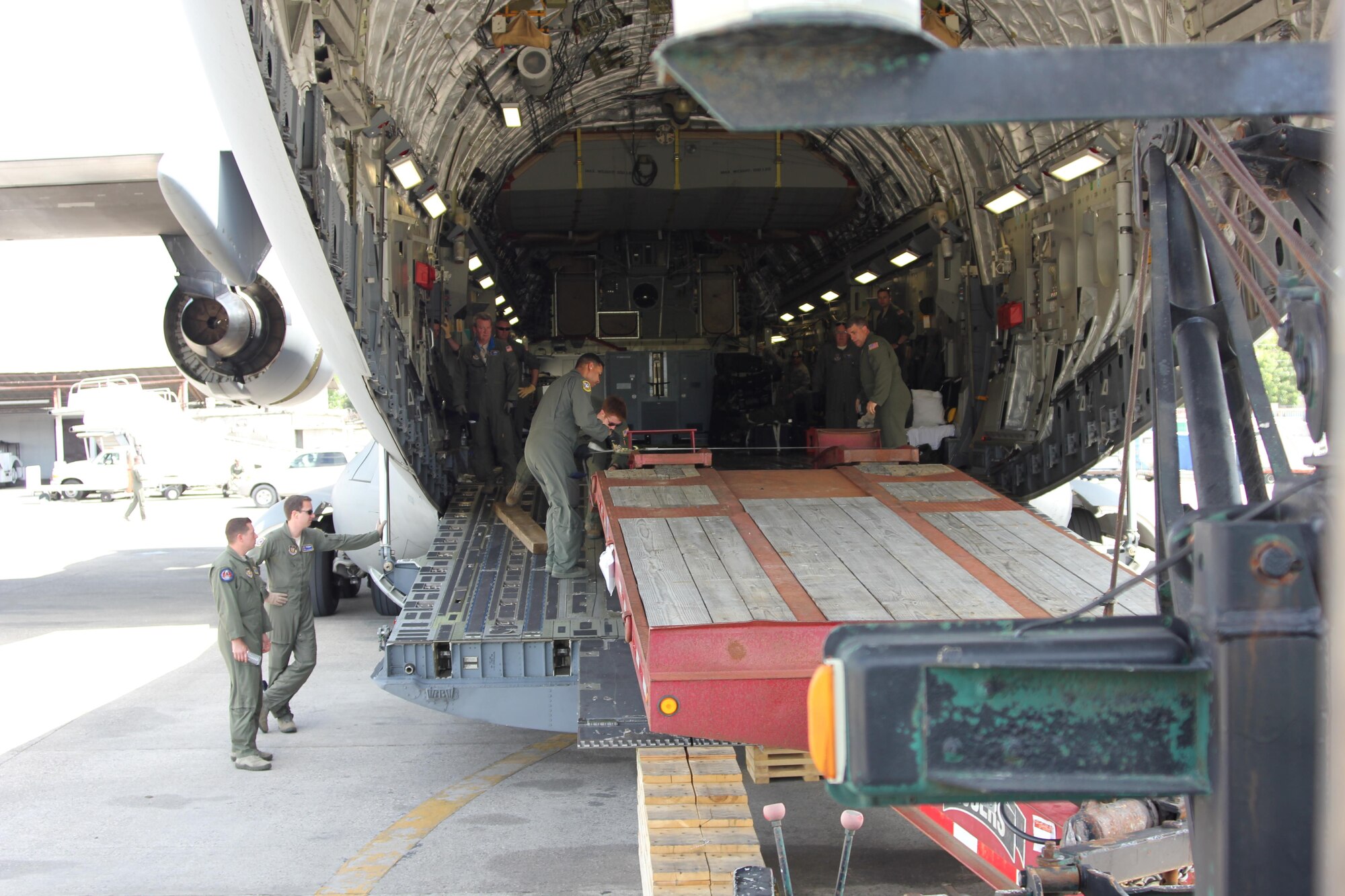 Members of the 732nd Airlift Squadron unload a trailer at the Toussaint L’Ouverture International Airport in Tabarre, near Port au Prince, Haiti. (U.S. Air Force photo released/Tech. Sgt. Thamara Jean Louis)