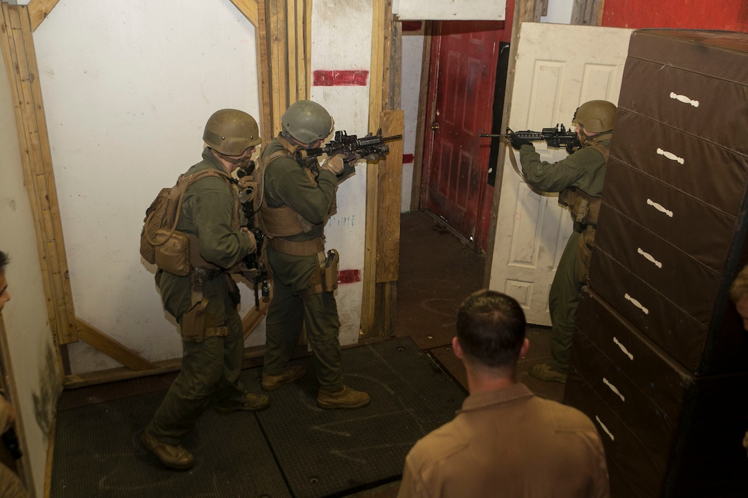 Close Quarters Battle instructors Staff Sgt. Jospeh Pistone and Cpl. David Poirier, Training Co., Marine Corps Security Force Regiment, monitor their students as they go through room-clearing exercises during the advanced safety evolution of the Close Quarter Battle course, aboard Naval Support Activity Northwest Annex, Chesapeake, Va., May 23. Advanced clearing was taught to the Marines over three days with a fourth day to evaluate them during a practical application exercise. (Official U.S. Marine Corps photo by Cpl. Logan Snyder)