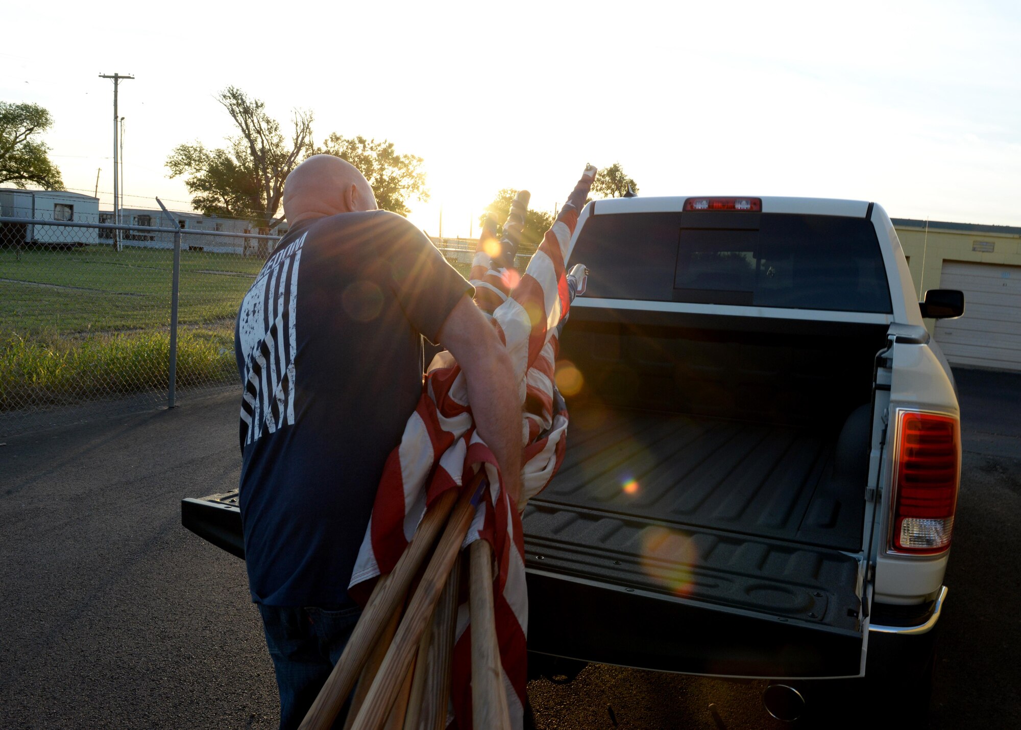 U.S. Air Force Senior Master Sgt. Shaun King, 97th Operations Support Squadron aircrew flight equipment superintendent, places flags in the bed of a truck, May 29, 2017, at Altus, Oklahoma. Members of the 97th OSS took time during the Memorial Day holiday to place flags around the community, showing support for community and base relations. The 97th OSS preforms this service six times a year for federal holidays that relate to the military. (U.S. Air Force Photo by Airman 1st Class Jackson N. Haddon/Released).