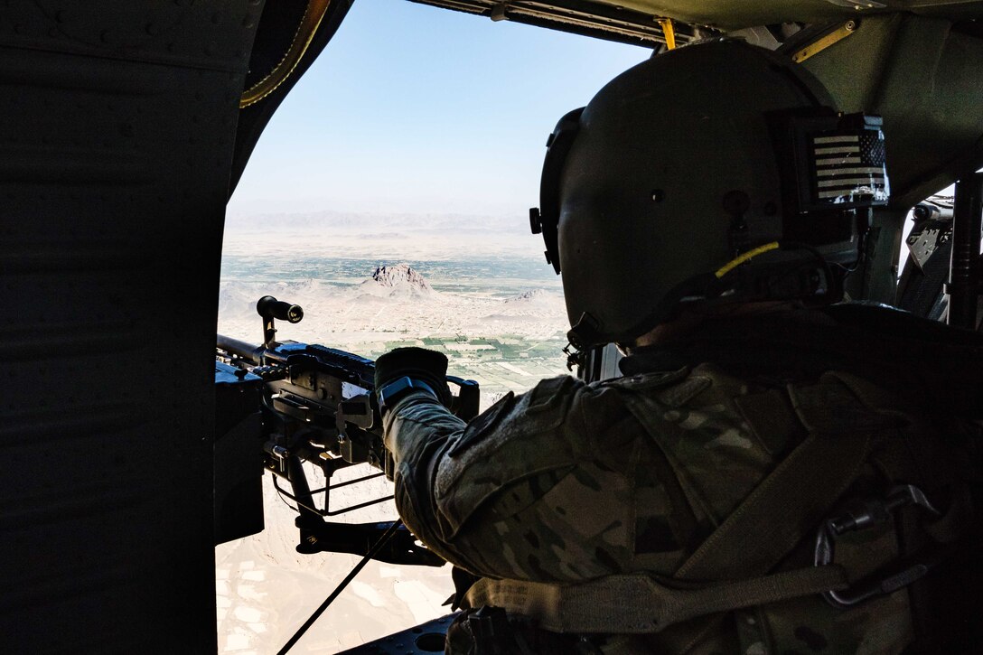 An Army crew chief scans the terrain below from the side window of a UH-60 Black Hawk helicopter during a flight near Kandahar, Afghanistan, May 27, 2017. Army photo by Capt. Brian Harris          