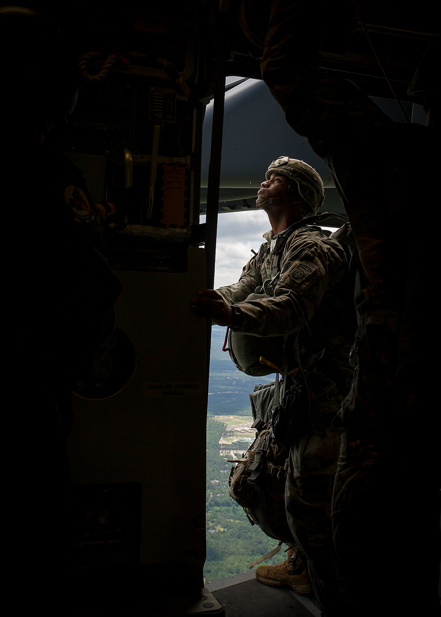 An 82nd Airbone Division jumpmaster checks outside a C-17 Globemaster III while en route to a Fort Bragg drop zone May 25.  Aircrews from the 315th and 437th Airlift Wings took off,  May 25, from Joint Base Charleston in 18 C-17 Globemaster IIIs within seconds of each other as part of a large formation exercise over Carolina skies. Exercise Bonny Jack was a joint service exercise with about 1,600 paratroopers from the 82nd Airborne Division at Fort Bragg.  (U.S. Air Force Photo / Master Sgt. Shane Ellis)

