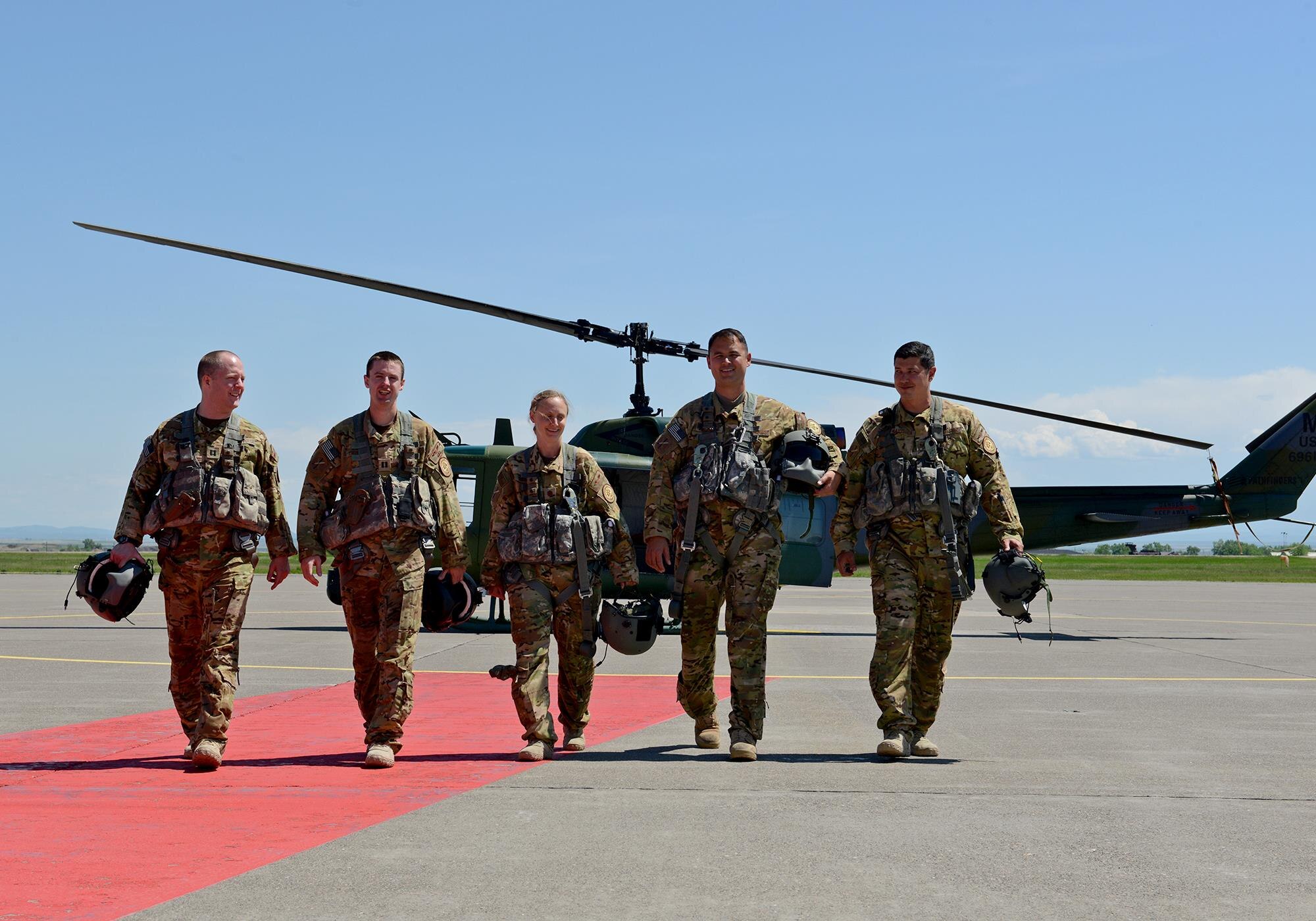 (From left to right) Capt. James Harris, 40th Helicopter Squadron co-pilot, Capt. Matt Thompson, 40th HS pilot, Maj. Melonie Parmley, 341st Medical Group flight surgeon, Tech. Sgts. Andrew Blankenship and Daniel Marchick, 40th HS special mission aviators, walk away from a helicopter May 30, 2017, at Malmstrom Air Force Base, Mont. The crew saved two girls and their dog Tuesday morning after the girls got lost while hiking in Sluice Boxes State Park Monday night. (U.S. Air Force photo/Staff Sgt. Delia Marchick)