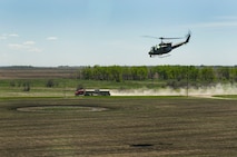 A UH-1N Iroquois huey from the 54th Helicopter Squadron flies alongside a semi-truck during a training sortie in the missile complex, N.D., May 23, 2017. The training sorties prepare aircrews for quick security response in the complex. (U.S. Air Force photo/Senior Airman Apryl Hall)