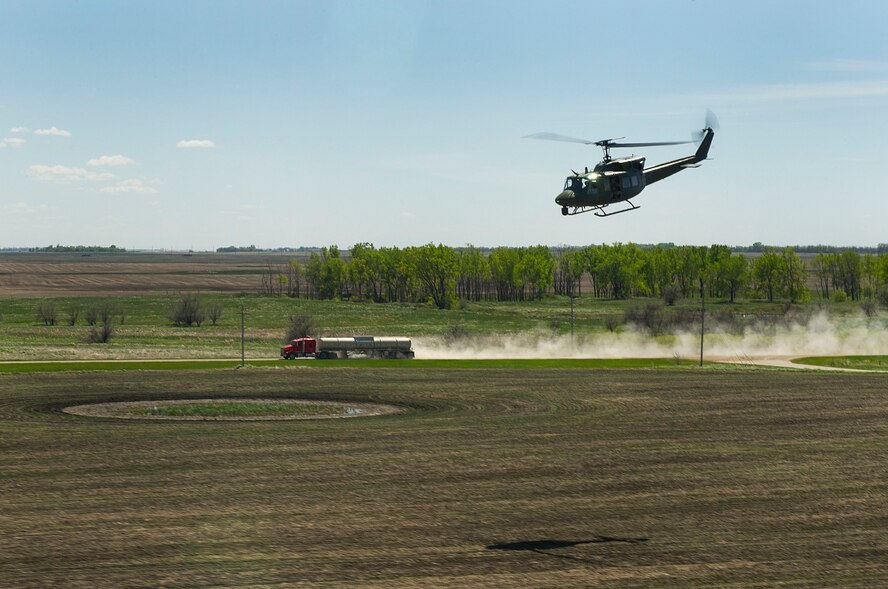 A UH-1N Iroquois huey from the 54th Helicopter Squadron flies alongside a semi-truck during a training sortie in the missile complex, N.D., May 23, 2017. The training sorties prepare aircrews for quick security response in the complex. (U.S. Air Force photo/Senior Airman Apryl Hall)