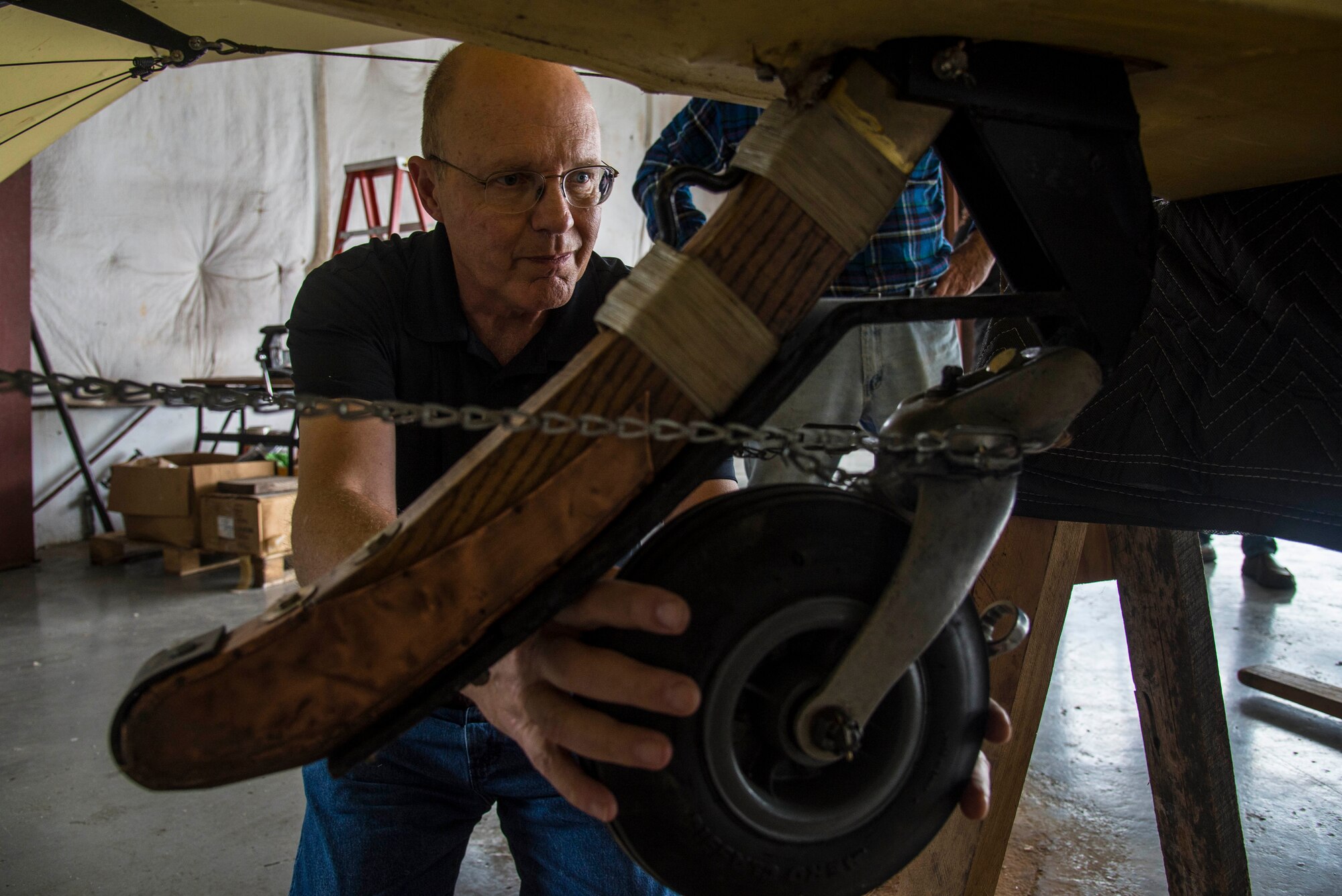 Myron Callaham, Board of Directors with Friends of Jenny, works on the tail wheel of the J-4 Jenny during some routine maintenance, May, 4, 2017 at Bowling Green, Kentucky. The Curtiss JN-4 is possible North America's most famous World War I aircraft. It was a twin-seat, student in front of instructor, dual-control biplane. Its tractor propeller and maneuverability made it ideal for initial pilot training. It was widely used during World War I to train begining pilots, with an estimated 95% of all trainees having flown a JN-4. (U.S. Air Force photo/Senior Airman Tristin English)