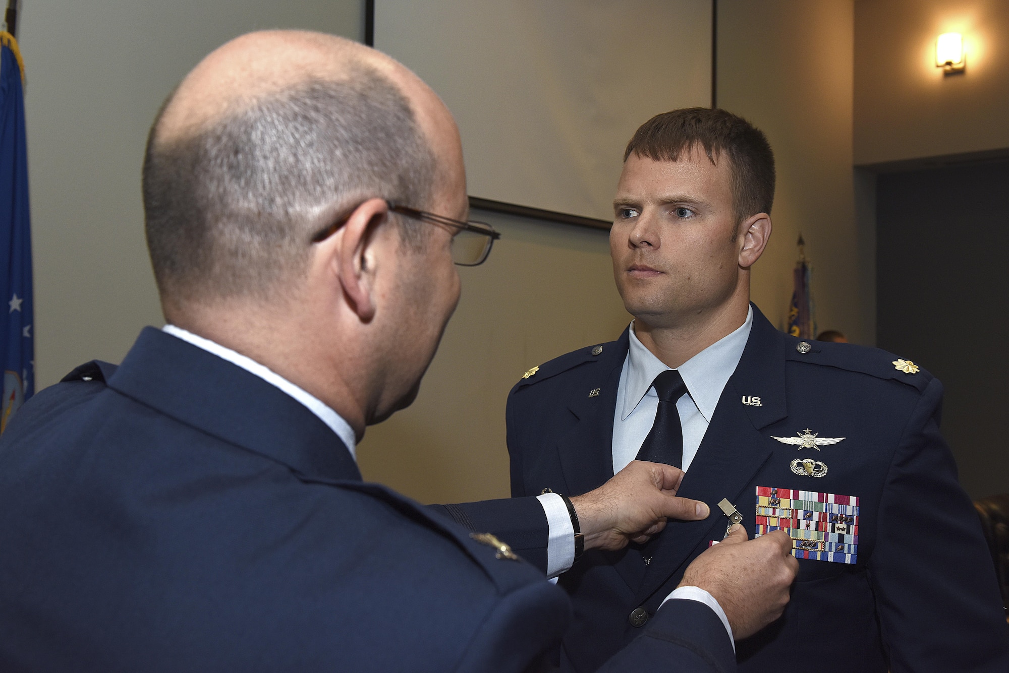 U.S. Air Force Maj. Stephen Maddox, 17th Communications Squadron commander, stands at attention as Col. Christopher Harris, 17th Mission Support Group commander, pins on a Meritorious Service medal during the 17th CS change of command ceremony at the Event Center on Goodfellow Air Force Base, Texas, May 31, 2017. Maddox received the medal for outstanding service to his unit by providing new equipment and deployment opportunities for Airmen despite low manning
