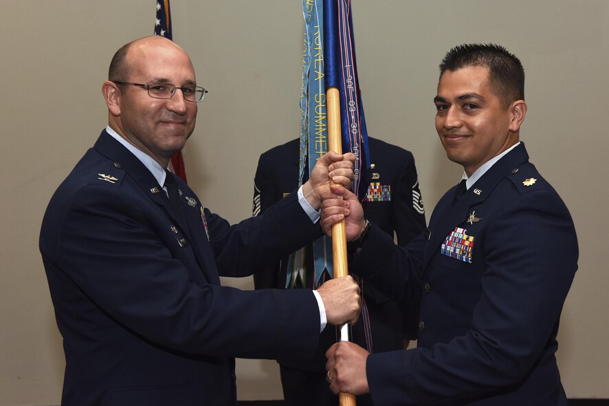 U.S. Air Force Maj. Mark Walkusky, the new 17th Communications Squadron Commander, takes the guideon from Col. Christopher Harris, 17th Mission Support Group Commander, during the 17th CS Change of Command ceremony at the Event Center on Goodfellow Air Force Base, Texas, May 31, 2017. (U.S. Air Force photo by Airman 1st Caelynn Ferguson/ Released)