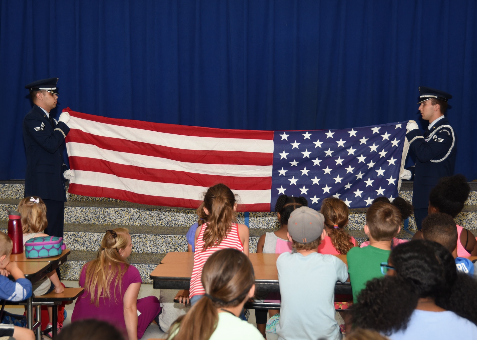U.S. Air Force Airmen from the 325th Fighter Wing Honor Guard team perform a U.S. flag folding at Bay Haven Charter Academy May 30, 2017. Airmen from Tyndall Air Force Base came to Bay Haven to talk about the meaning of the U.S. flag, sing the National Anthem, perform a proper flag folding and talk to children about everyday Air Force life. (U.S. Air Force photo by Senior Airman Sergio A. Gamboa/Released) 