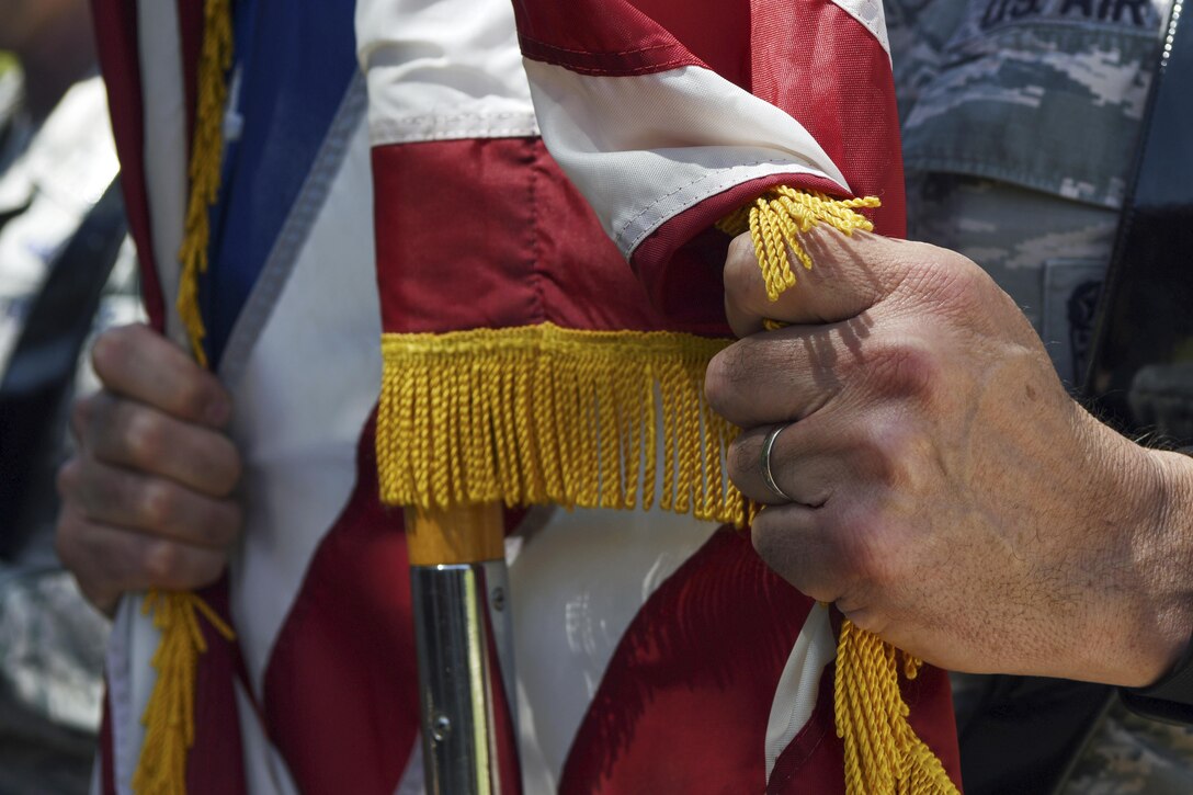 U.S. Air Force Chief Master Sgt. Glen Pugh, 7th Maintenance Group superintendent, snaps a flag in place during a flag detail practice at Dyess Air Force Base, Texas, April 4, 2017. Pugh and other Dyess chiefs participated in Dyess Honor Guard training as another way to lead today’s Airmen. (U.S. Air Force photo by Senior Airman Kedesha Pennant)

 
