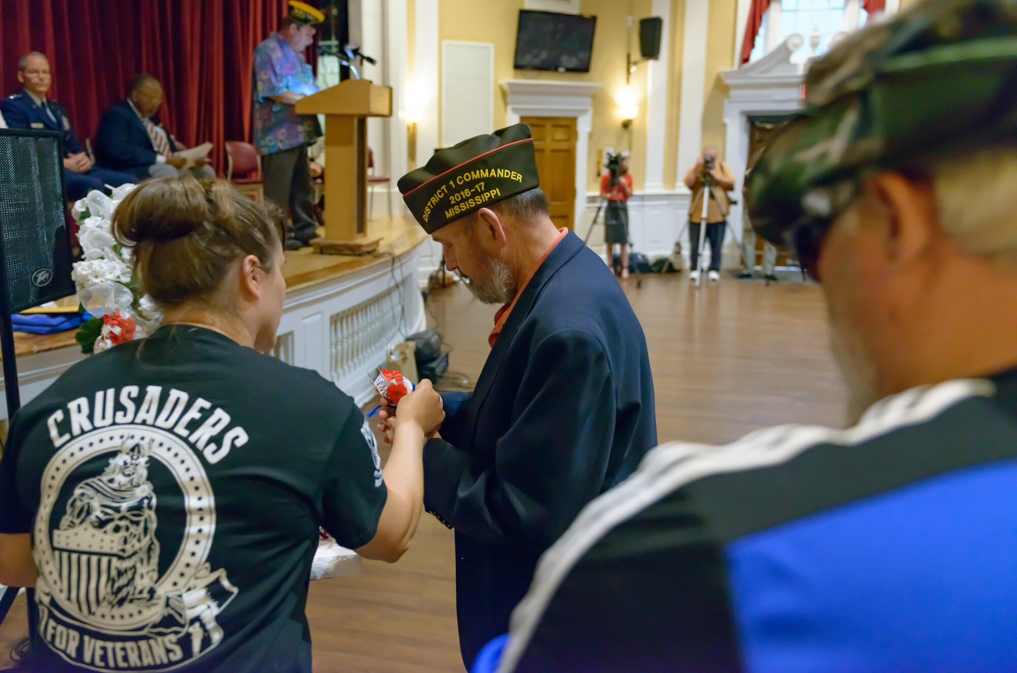 Petty Officer 1st Class Roxanne Cuttill, Center for Naval Aviation Technical Training Unit Keesler Aerog-rapher’s Mate, hands a poppy flower to a veteran during the Memorial Day Ceremony at the Biloxi National Cemetery May 29, 2017, in Biloxi, Miss. The ceremony paid homage to those who have made the ultimate sacrifice while serving in the armed forces. (U.S. Air Force photo by Andre’ Askew)