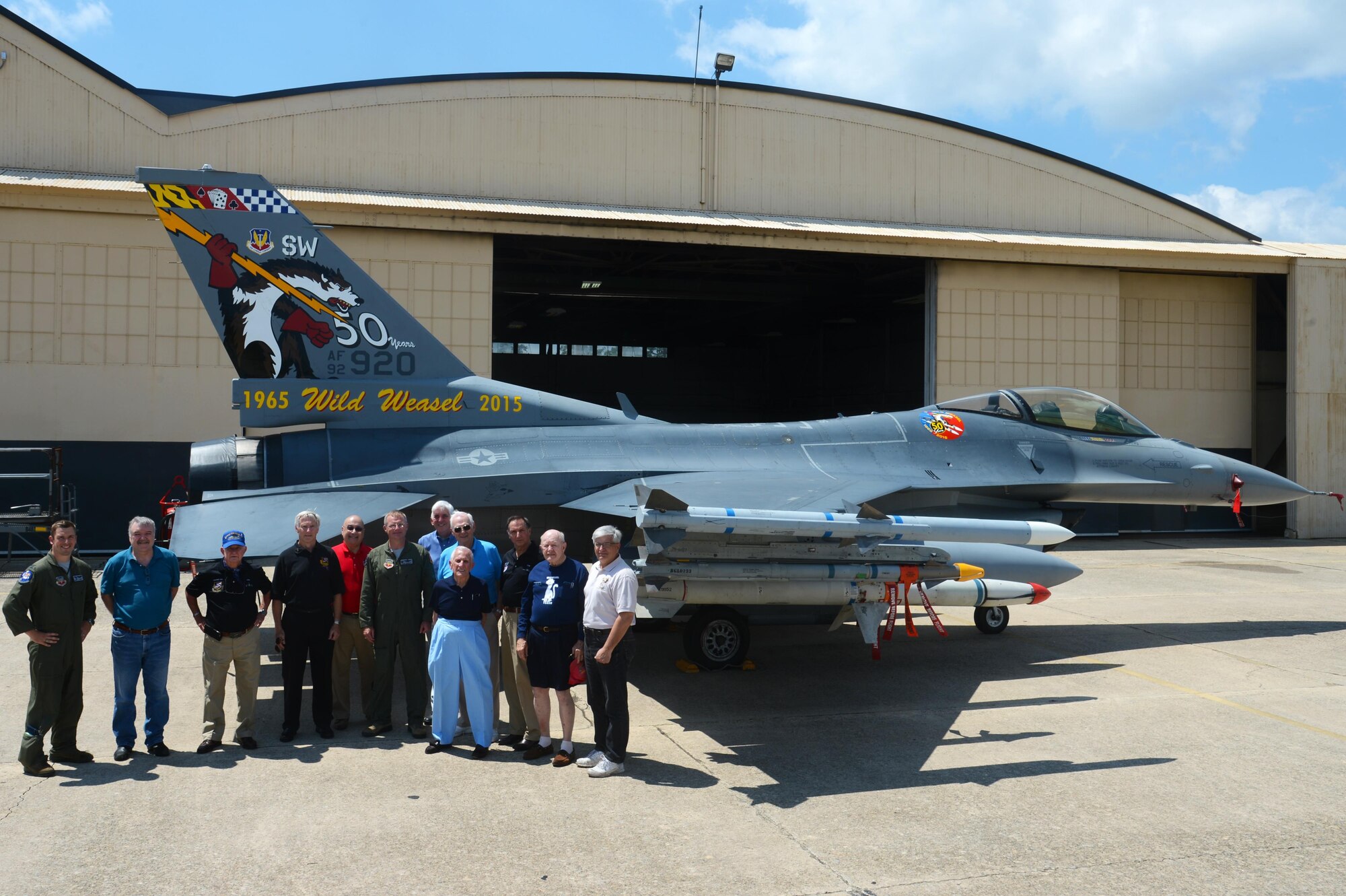 Retired U.S. Air Force Wild Weasels pose for a photo with present Wild Weasels in front of the 50th anniversary 20th Fighter Wing flagship F-16CM Fighting Falcon tail flash at Shaw Air Force Base, S.C., June 5, 2015. A conference is scheduled to be held June 22 to 25, 2017, in recognition of the Wild Weasels 52nd anniversary.