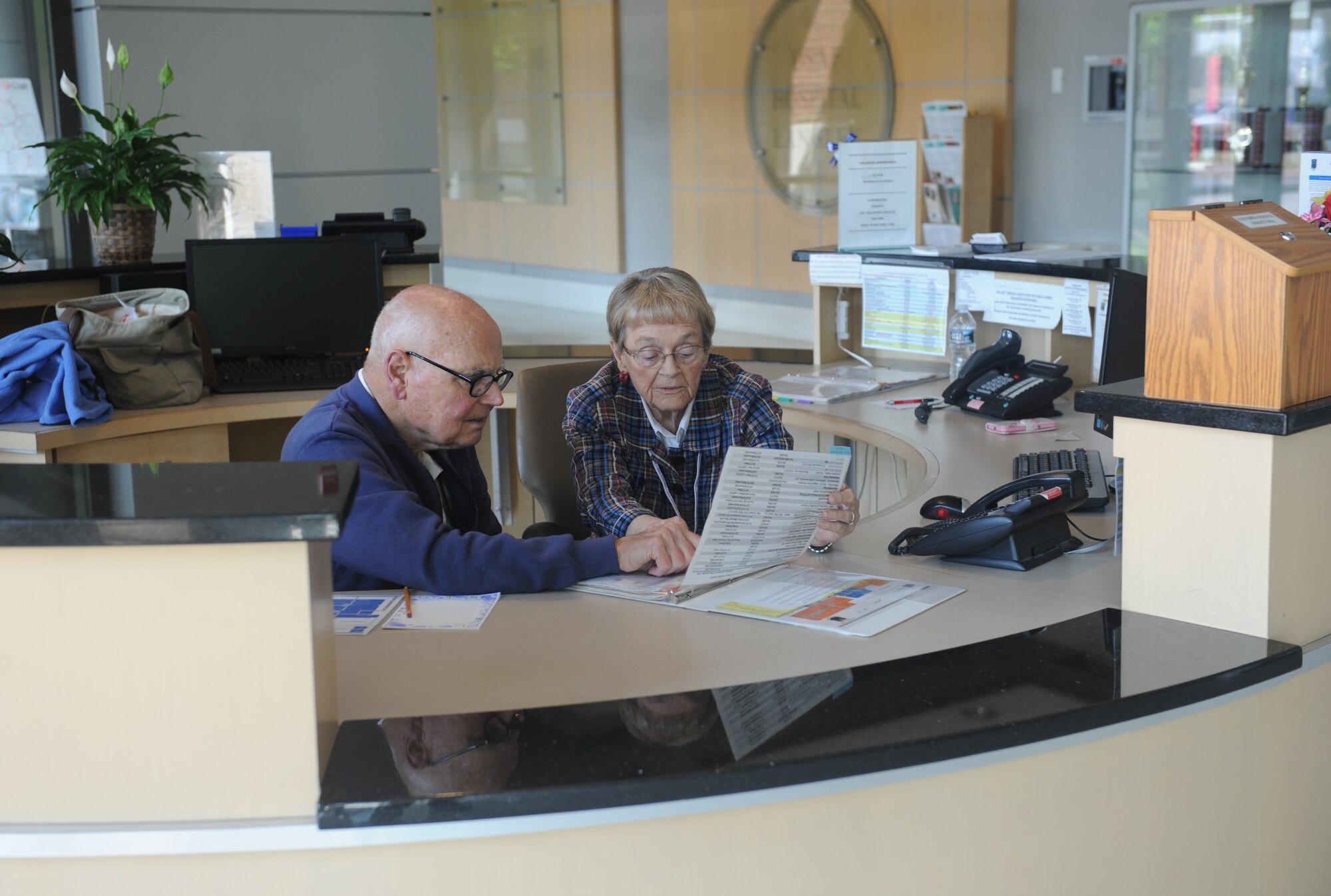 Retired U.S. Air Force Lt. Col. David Howell, U.S. Air Force Hospital Langley volunteer, and his wife, Barbara Howell, hospital volunteer, consult an information desk directory at Joint Base Langley-Eustis, Va., May 17, 2017. The Howells are part of a team of seven retired couples who volunteer for more than 300 hours each month at the hospital. (U.S. Air Force photo/Beverly Joyner)