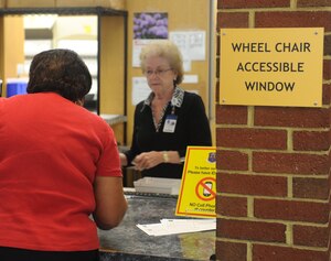 U.S. Air Force Hospital Langley volunteer Mary Rehak, wife of retired U.S. Air Force Capt. Robert Rehak, hospital volunteer, delivers prescription medication to a beneficiary at the satellite pharmacy at Joint Base Langley-Eustis, Va., May 22, 2017. Mary and Robert are part of a team of seven retired hospital volunteer couples, and both volunteer at the pharmacy two days a week. (U.S. Air Force photo/Beverly Joyner)