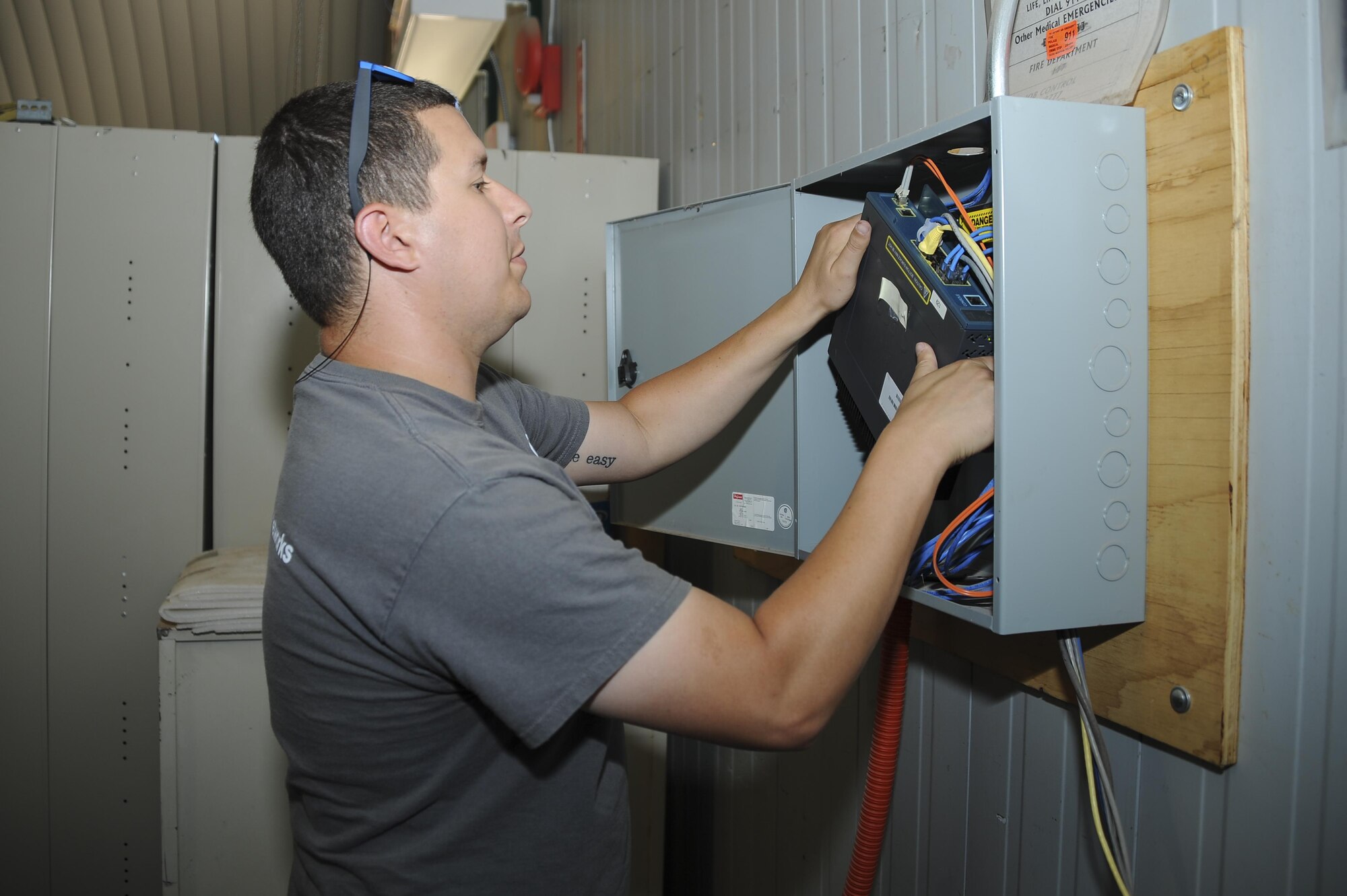 Brodie Carrier, Consolidated Networks fiber technician, removes an old communications cabinet at the 309th Aircraft Maintenance and Regeneration Group at Davis-Monthan Air Force Base, Ariz., May 24, 2017. The fiber technicians can reinstall up to two communications cabinets in a day. (U.S. Air Force photo by Senior Airman Mya M. Crosby)