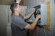 Brodie Carrier, Consolidated Networks fiber technician, removes an old communications cabinet at the 309th Aircraft Maintenance and Regeneration Group at Davis-Monthan Air Force Base, Ariz., May 24, 2017. The fiber technicians can reinstall up to two communications cabinets in a day. (U.S. Air Force photo by Senior Airman Mya M. Crosby)