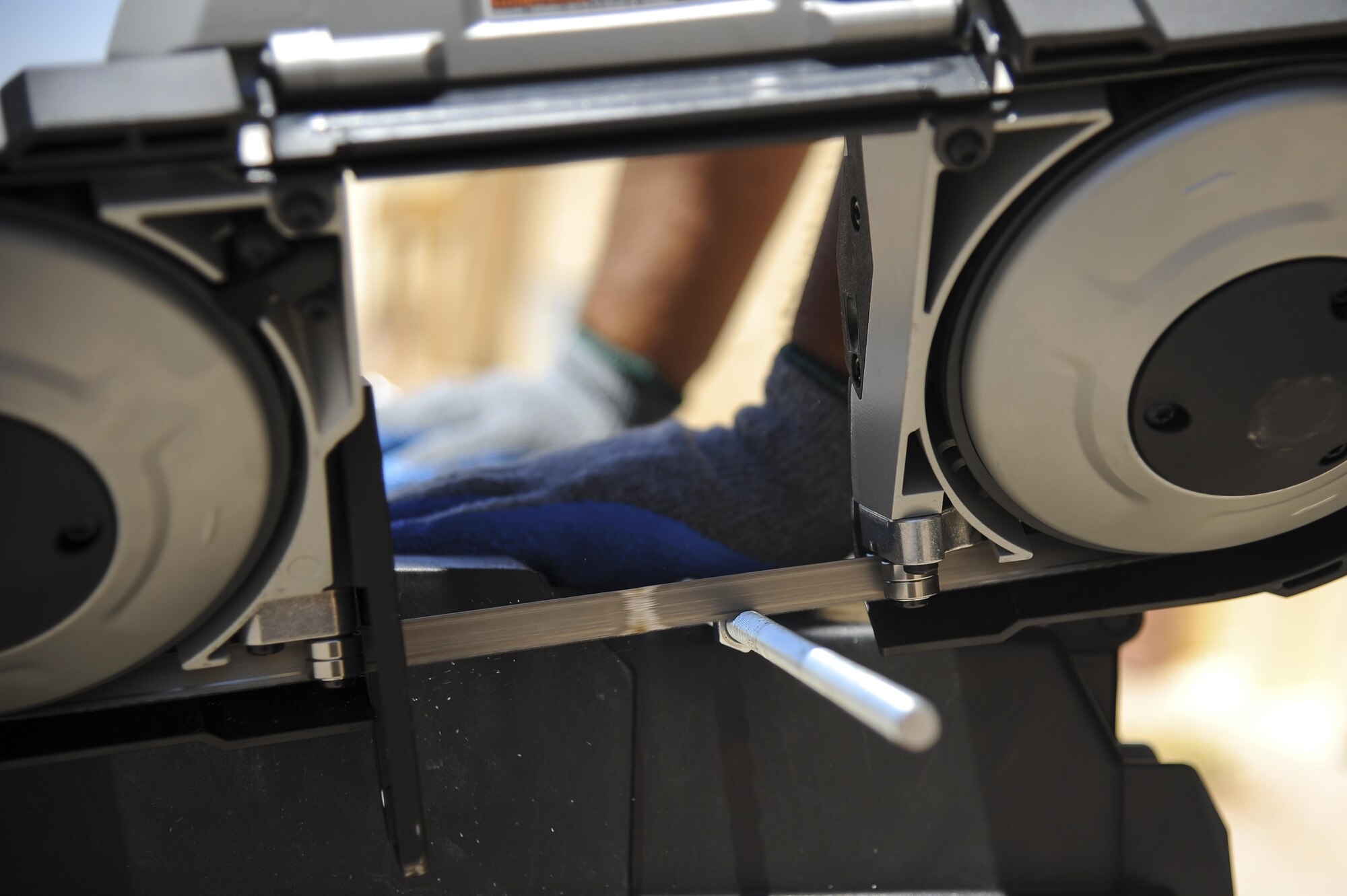 A fiber technician from Consolidated Networks, uses a band saw to cut an all thread for a communications cabinet installation at the 309th Aircraft Maintenance and Regeneration Group at Davis-Monthan Air Force Base, Ariz., May 24, 2017. The contractors and 355th Communications Squadron Airmen have been in the process of creating and executing a modification plan, upgrading D-M’s network without interfering with any of the Desert Lightning Team’s connectivity.  (U.S. Air Force photo by Senior Airman Mya M. Crosby)