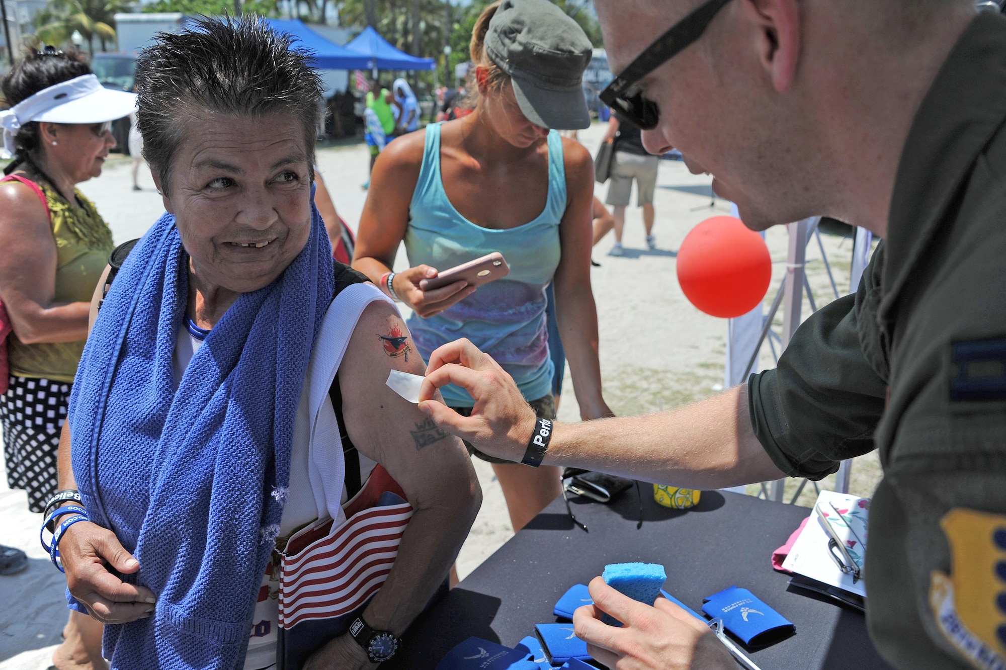 A Salute to America’s Heroes Air and Sea Show attendee receives a B-1B Lancer tattoo from Capt. Christopher Williston, 34th Bomb Squadron B-1B Lancer Weapons System Officer, at Miami Beach, Fla., May 28, 2017. Bomber Airmen attended the airshow to eduate and the public and generate awarenss of their respctive aircraft’s mission and capabilities. (U.S. Air Force photo by Senior Airman Erin Trower)