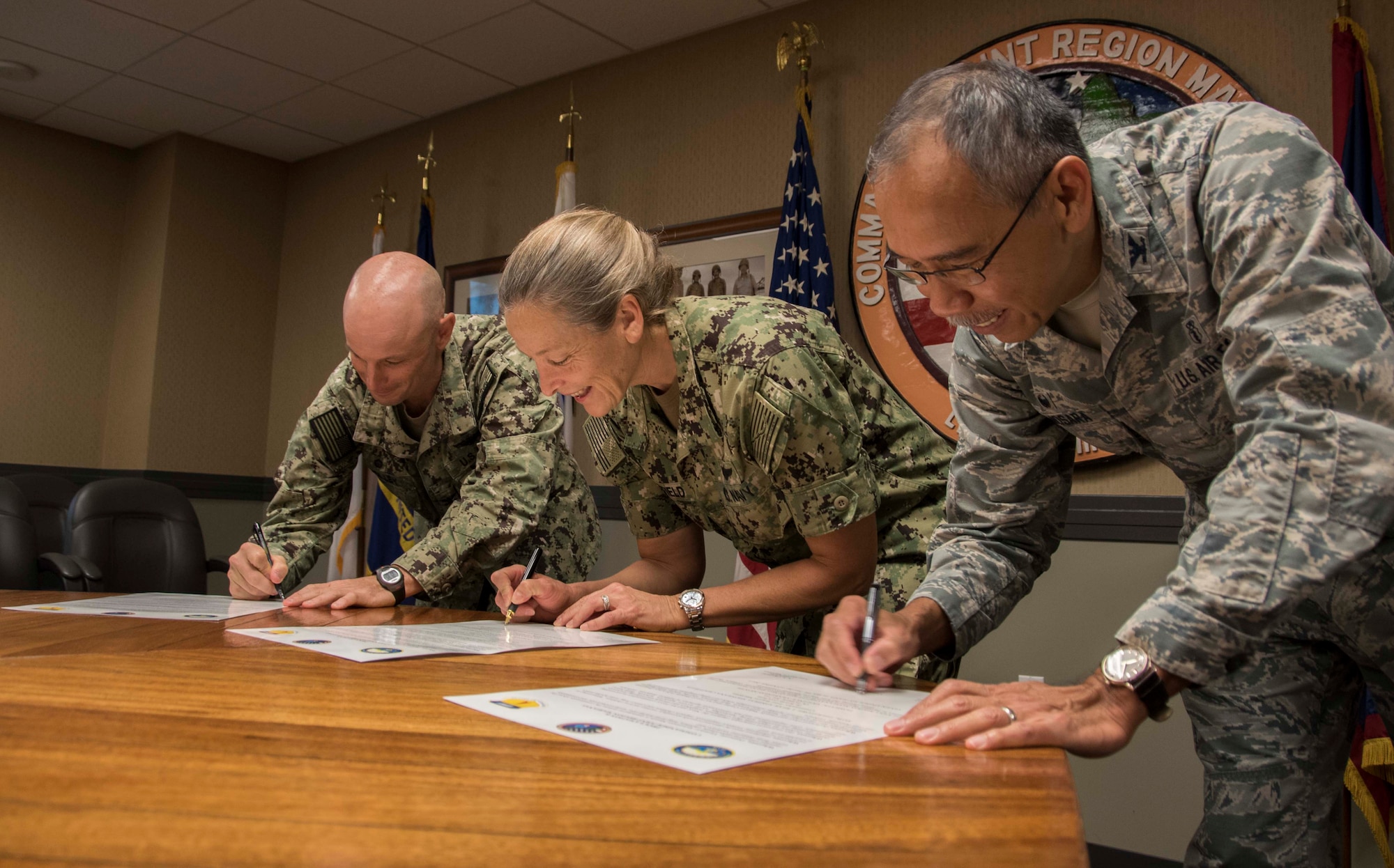 From left, U.S. Navy Capt. Hans Sholley, Naval Base Guam commanding officer, U.S. Navy Rear Adm. Shoshana Chatfield, Joint Region Marianas (JRM) commander and U.S. Air Force Col. Joel Almosara, 36th Medical Group commander, sign the Domestic Violence Awareness Month proclamation at JRM headquarters in Asan, Guam, Oct. 2, 2017. Domestic violence is an offense under the United States Code, the Uniform Code of Military Justice and state law. Regulations require military and Department of Defense officials to report any suspicion of family violence. This includes commanders, first sergeants, supervisors, medical personnel and military police. (U.S. Navy photo by JoAnna Delfin)