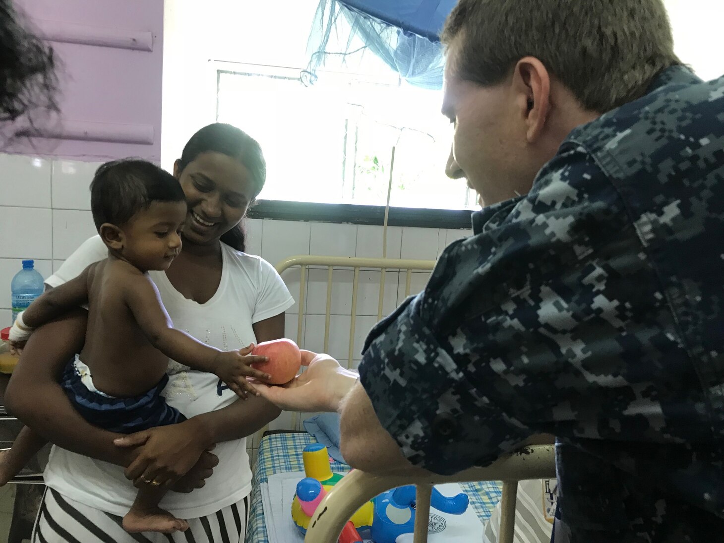Lt. Cmdr. Scott Mehaffey, a native of Norfolk assigned to Ticonderoga-class guided-missile destroyer USS Princeton (CG 59), offers fruit to a boy during a volunteer event at Lady Ridgeway Hospital in Colombo, Sri Lanka. Princeton is part of Nimitz Carrier Strike Group on a regularly scheduled deployment in the 7th Fleet area of responsibility in support of maritime security operations and theater security cooperation efforts.