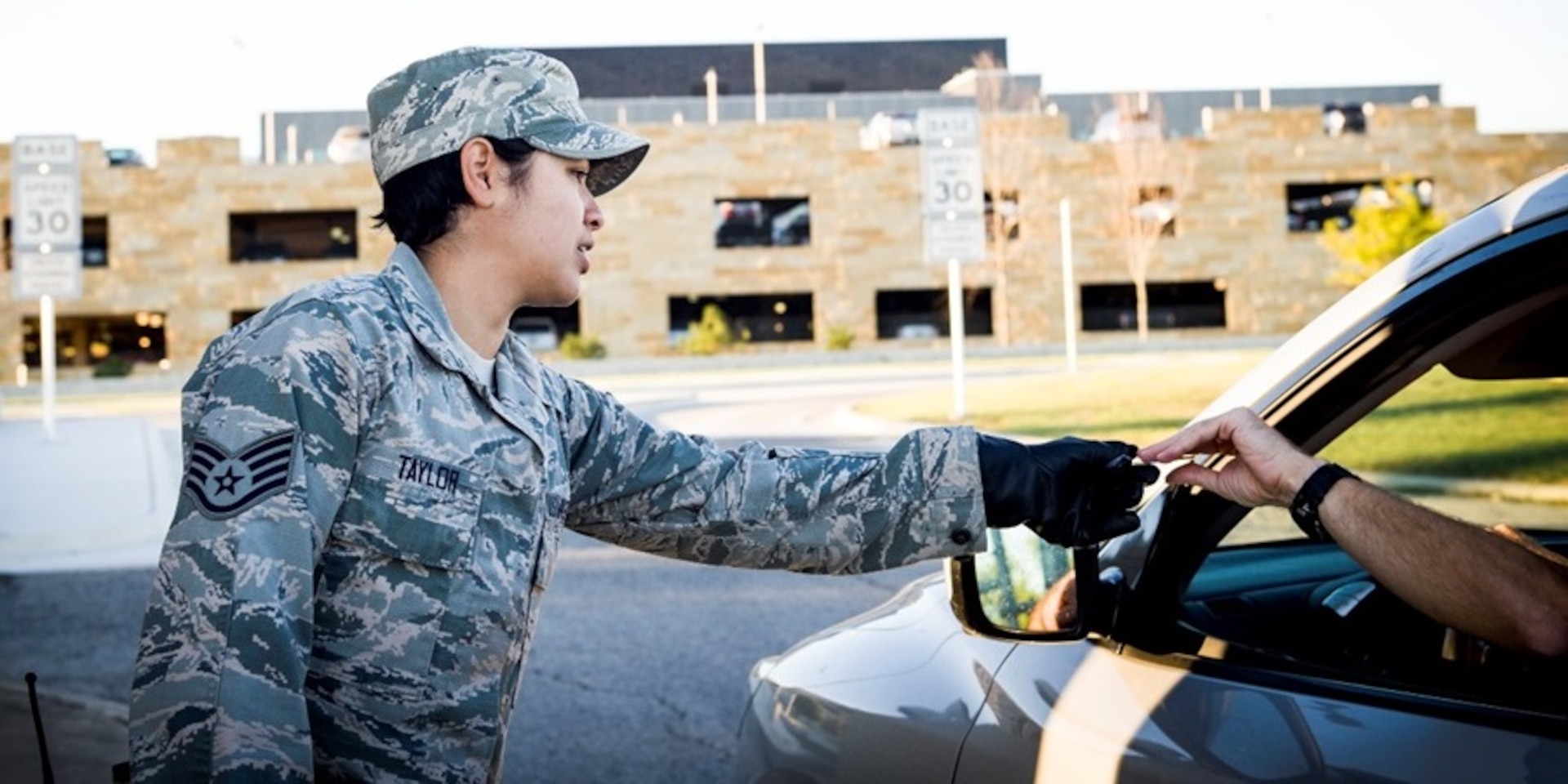 Staff Sgt. Mellissa Taylor, 559th Trainee Health Squadron optometry noncommissioned officer in charge, checks an ID at the Highway 90 gate while performing security forces augmentee duty Oct. 23 at Joint Base San Antonio-Lackland. The Highway 90 gate provides easy and convenient access for patients to quickly access care and facilities.