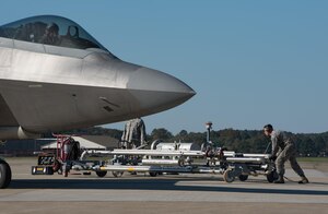 U.S. Air Force Airman 1st Class Aurelio Renteria-Gamez, 733rd Logistics Readiness Squadron fuels distribution operator, pushes a pantograph refueling system underneath a U.S. Air Force F-22 Raptor during hot refueling at Joint Base Langley-Eustis, Va., Oct. 31, 2017.