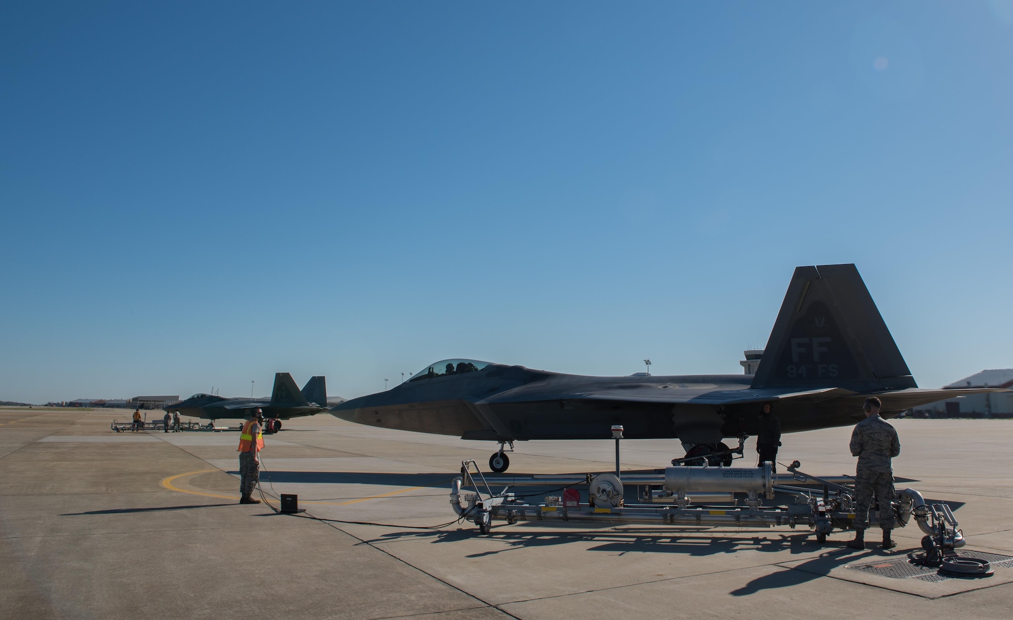 U.S. Air Force crew chiefs assigned to the 1st Fighter Wing and 733rd Logistics Readiness Squadron fuel operators use pantograph fueling systems to fuel U.S. Air Force F-22 Raptors during hot refueling operations at Joint Base Langley-Eustis, Va., Oct. 31, 2017.