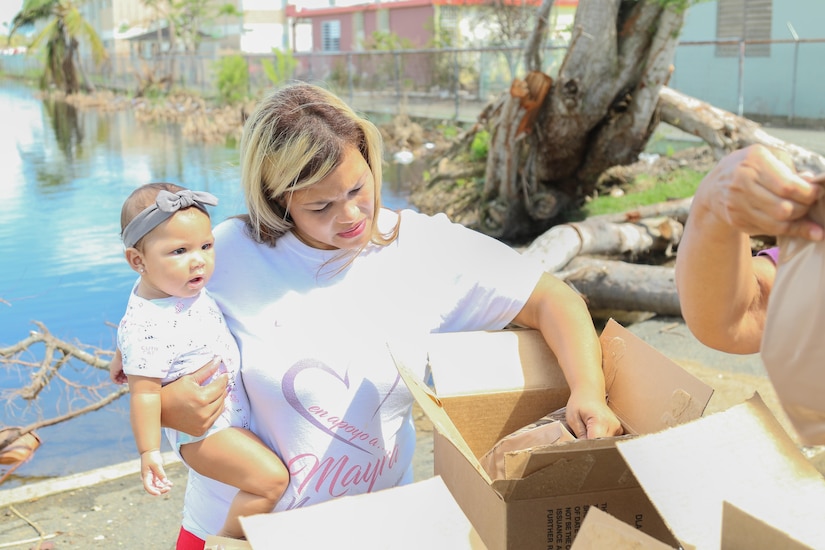 A mother and daughter collect food and water from an Army distribution point in Humacao, Puerto Rico.