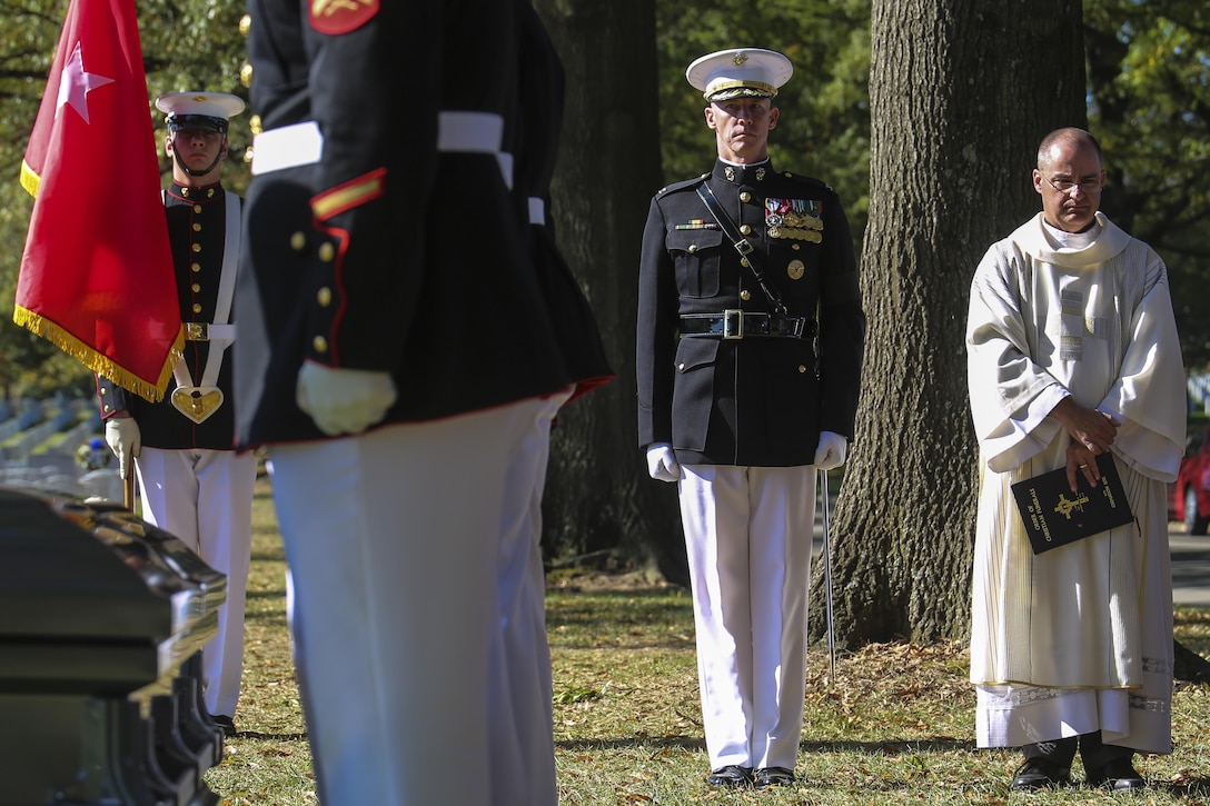 Colonel Tyler J. Zagurski, commanding officer, Marine Barracks Washington D.C., stands at the position of attention accompanied by the appointed funeral priest during a full honors funeral for Maj. Gen. Terrence R. Murray at Arlington National Cemetery, Arlington, Va., Oct. 31, 2017. Marine Barracks Washington is home to the Marines who provide support for all Marine Corps funerals and many high-ranking government officials’ funerals within the National Capitol Region. (Official U.S. Marine Corps photo by Cpl. Damon Mclean/Released)