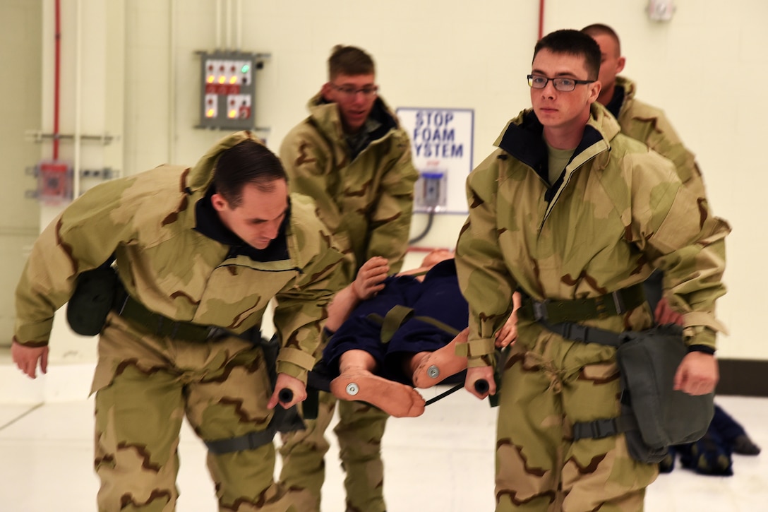 Airmen carry a medical mannequin on a litter during training.
