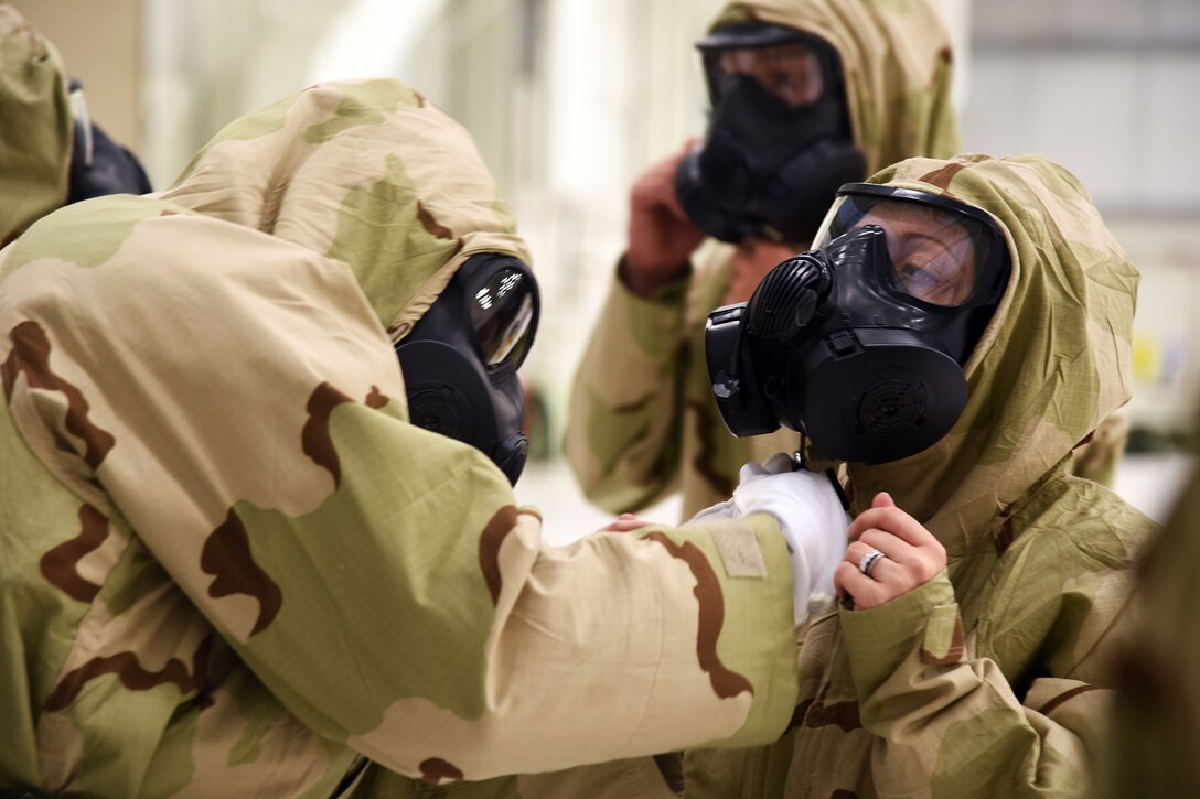 Airmen check chemical gear during training.