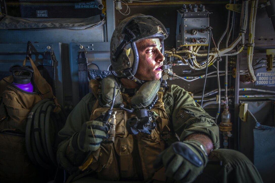 A Marine looks out the window of an aircraft