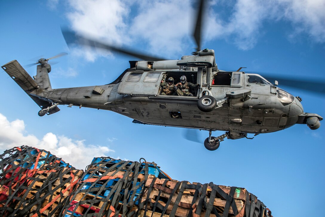 A helicopter approaches cargo.