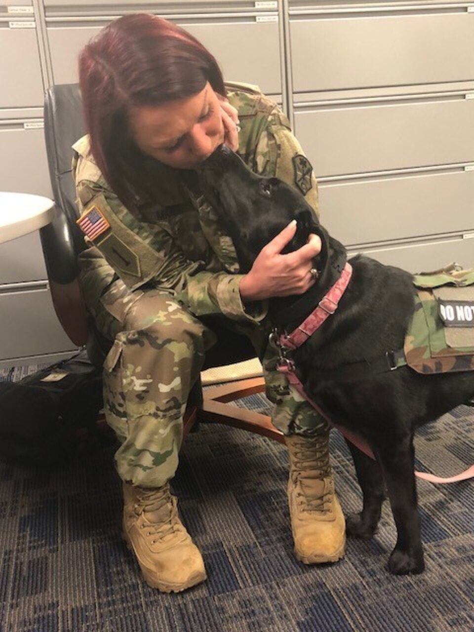 Army Master Sgt. Leigh Michel gets a kiss from her service dog, Lizzy
