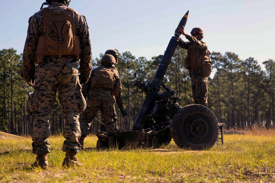 Marines load a round into a mortar.