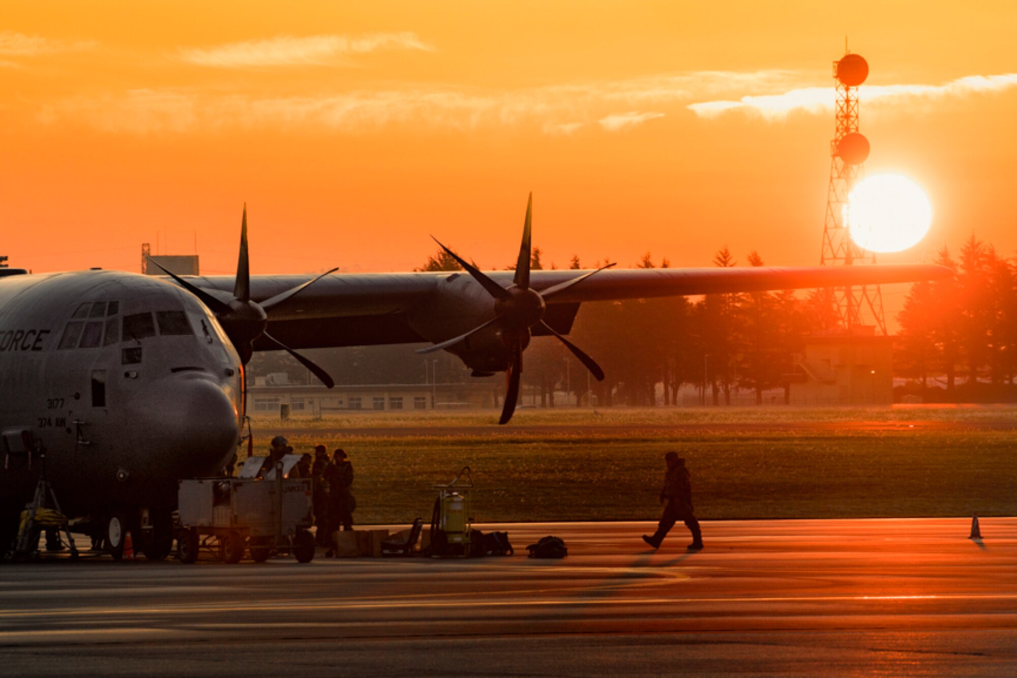 A crew chief assigned to the 374th Aircraft Maintenance Squadron walks on the flightline at Yokota Air Base, Japan, Oct. 26, 2017. Yokota received the C-130J Super Hercules from Dyess Air Force Base, Texas, and crew chiefs maintain the aircraft 24/7 during the Exercise Beverly Morning 17-06.