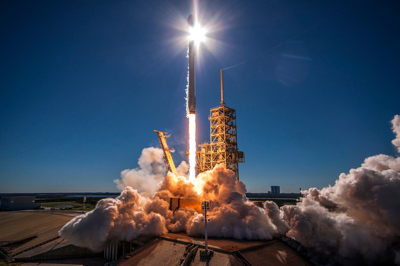 A rocket launches into the sky with the sun behind it.