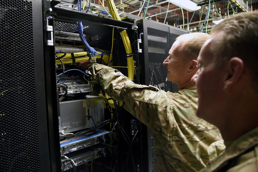 Col. William Burks, 455th Air Expeditionary Wing vice commander, plugs the new Comprehensive Airman Fitness network Ethernet cable into a server rack Oct. 31, 3017 at Bagram Airfield, Afghanistan.
