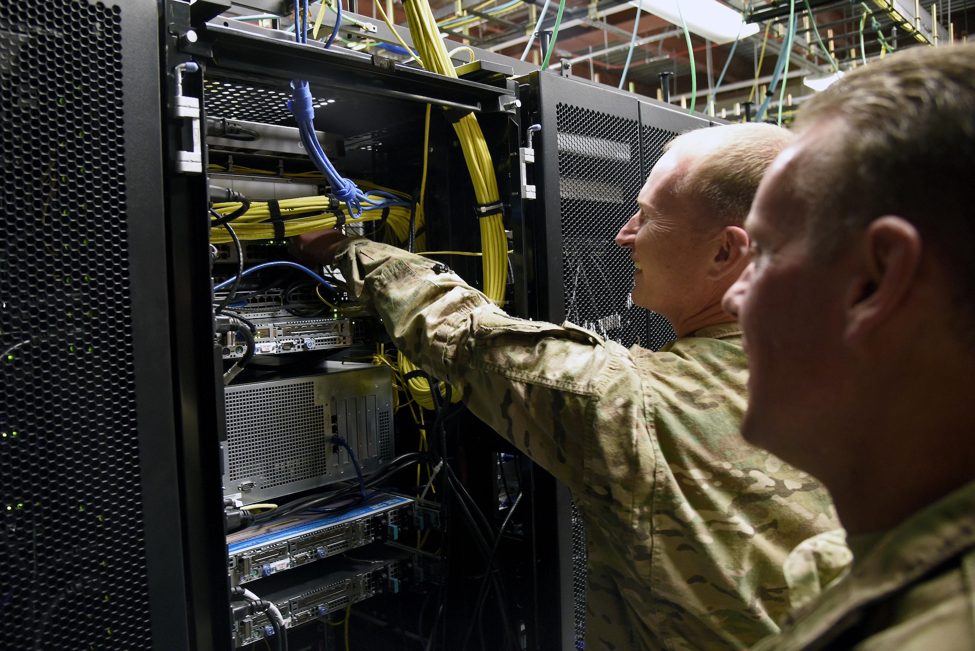 Col. William Burks, 455th Air Expeditionary Wing vice commander, plugs the new Comprehensive Airman Fitness network Ethernet cable into a server rack Oct. 31, 3017 at Bagram Airfield, Afghanistan.