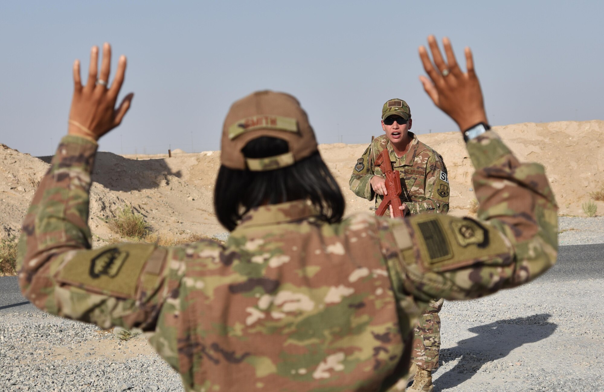 U.S. Air Force Tech. Sgt. Lacey Bunkelman, 407th Expeditionary Security Forces Squadron augmentee trainer, demonstrates challenging procedures near the 407th ESFS on the 407th Air Expeditionary Group Oct. 30. Bunkelman helped train 300 augmentees on a variety of security forces procedures. (U.S. Air Force photo by Staff Sgt. Joshua Edwards/Released)