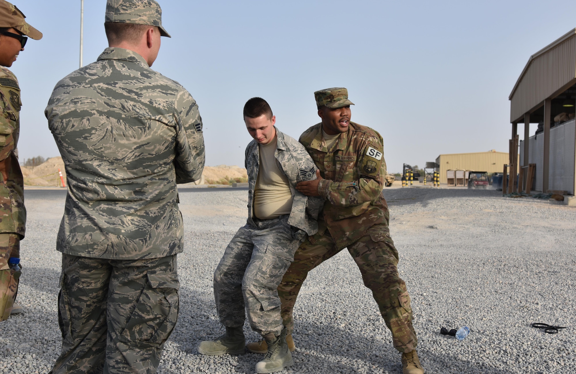 U.S. Air Force Tech. Sgt. Ronnie Jones, 407th Expeditionary Security Forces Squadron augmentee trainer, demonstrates maintaining control of an individual during a search near the 407th ESFS on the 407th Air Expeditionary Group Oct. 30. Jones has shown this procedure to over 300 security forces augmentees. (U.S. Air Force photo by Staff Sgt. Joshua Edwards/Released)